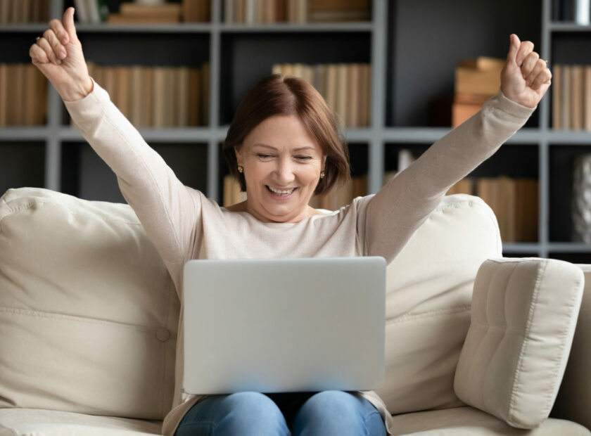 Excited mature woman looking at laptop screen, reading good news