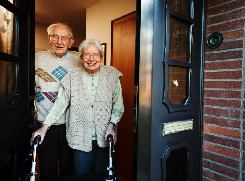 elderly couple opening the front door